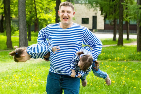 Happy father holds on hands charming daughters-twins — Stock Photo, Image