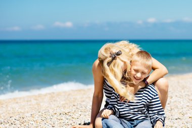 Güzel genç kadın oğlunu denize sıfır plaj üzerinde hugs