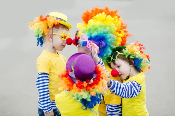 Jeune femme et trois petits enfants en costume de clown — Photo