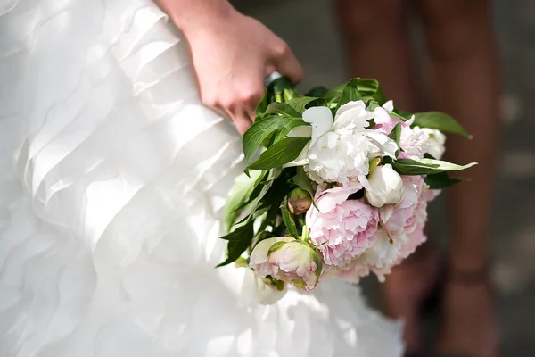 Gentle wedding bouquet with peonies in hands of the bride — Stock Photo, Image