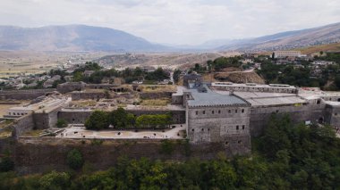 Aerial view of the Gjirokaster Fortress standing on the hill overlooking the town and mountains