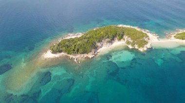 Drone view of a single small island in Ksamil Albania surrounded by turquoise waters and coastline