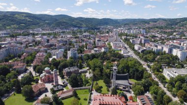 Drone aerial view of Banja Luka showing historic churches, city buildings, and surrounding urban landscape