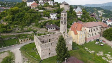 Drone aerial view of Saint Marys Church in Jajce showing the church structure and surrounding cityscape