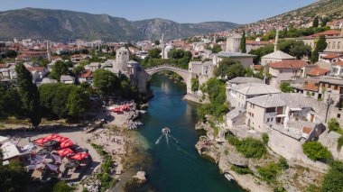 İnsansız hava aracı fotoğrafı Stari Most köprüsünü ve Mostar şehrinin çevresini Neretva Nehri ve tarihi eski kasabasıyla gösteriyor..