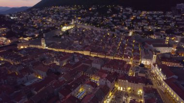 Stradun 'un insansız hava aracı fotoğrafı, Dubrovniks ana caddesi, geceleri sıcak ışıklarla parlıyor..