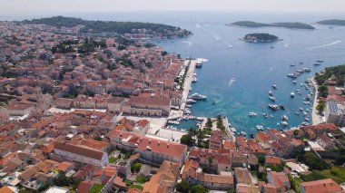 Hava aracı fotoğrafı Hvar 'ın eski kasaba çatılarını, limanlarını ve Adriyatik Denizi' ni gösteriyor..