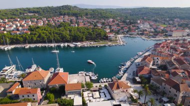 İnsansız hava aracı fotoğrafı Stari Grad limanını, eski kasabanın kırmızı çatılarını ve Adriyatik Denizi 'nin çevresindeki yeşillikleri gösteriyor..