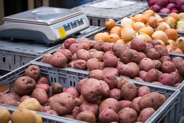 Patatas, cebollas y rábanos en un mercado de agricultores — Foto de Stock