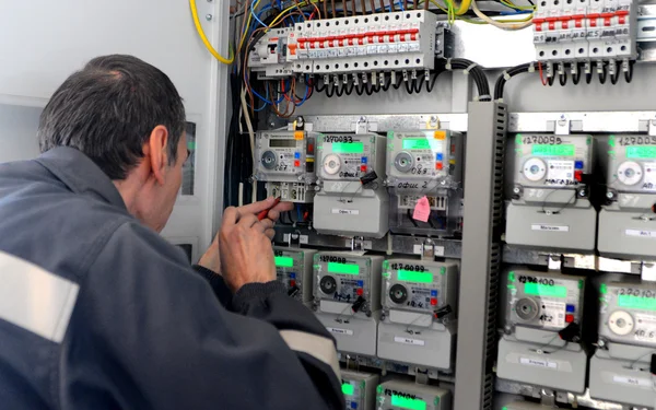 Ingegnere costruttore di elettricisti che ispeziona apparecchiature elettriche da banco — Foto Stock
