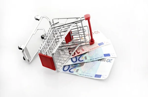 Conceptual studio shot of a bunch of euro banknotes filling a shopping cart on white background — Stock Photo, Image