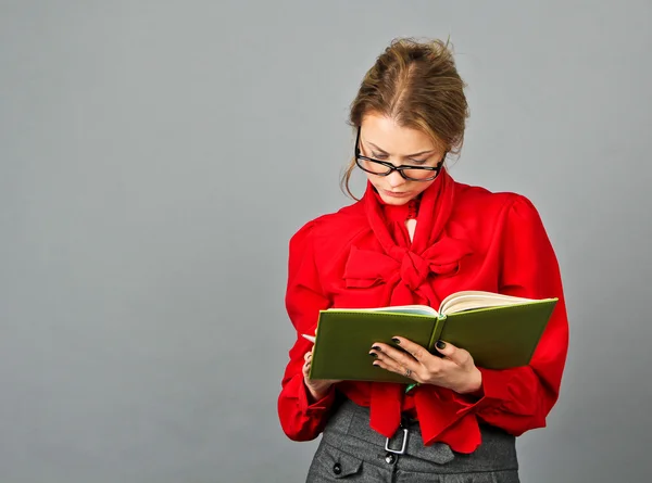 Mujer pensativa en blusa roja mirando sus notas —  Fotos de Stock