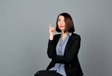 Güzel iş kadın oturuyordu ve işaret parmağı yukarıya