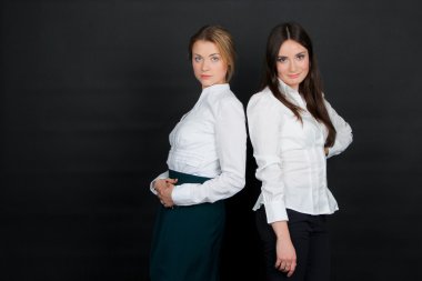 İki güzel genç esmer kız ayakta beyaz bluz