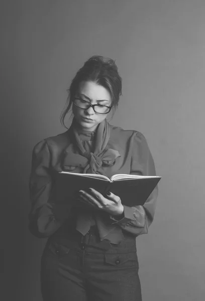 Chica joven con libro en estudio aislado en negro —  Fotos de Stock