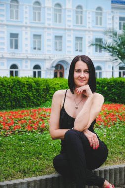 Güzel, esmer bir kadın parkın dışında dinleniyor. Gülümse, Batumi, Georgia 'daki tatlı kız. Yaz zamanı..