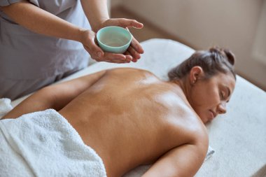 Masaj salonundaki genç çekici kadın güzellik ve sağlık prosedürleri uyguluyor.