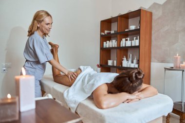 Masaj salonundaki genç çekici kadın güzellik ve sağlık prosedürleri uyguluyor.