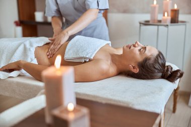 Masaj salonundaki genç çekici kadın güzellik ve sağlık prosedürleri uyguluyor.