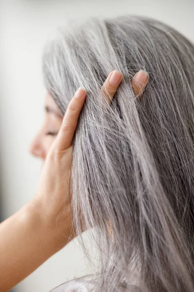 感情的な肖像画の長い髪アジアの成熟した女性上の灰色の背景 — ストック写真