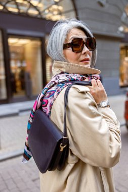 Olgun soluk saçlı, şık kadın tarzı şehir dışında çekilmiş bir portre.