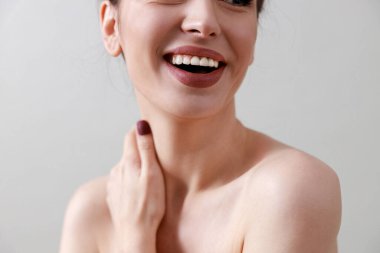 Stüdyo güzelliği portresi. Gri bir arka planda genç, sağlıklı, güzel, taze tenli beyaz bir kadın.