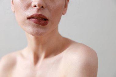 Stüdyo güzelliği portresi. Gri bir arka planda genç, sağlıklı, güzel, taze tenli beyaz bir kadın.