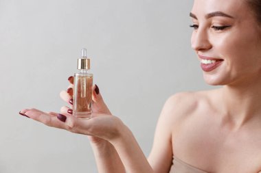 Stüdyo güzelliği portresi. Gri bir arka planda genç, sağlıklı, güzel, taze tenli beyaz bir kadın.