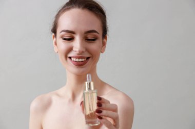 Stüdyo güzelliği portresi. Gri bir arka planda genç, sağlıklı, güzel, taze tenli beyaz bir kadın.