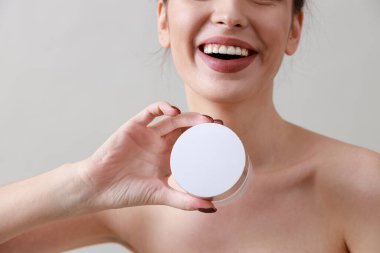 Stüdyo güzelliği portresi. Gri bir arka planda genç, sağlıklı, güzel, taze tenli beyaz bir kadın.