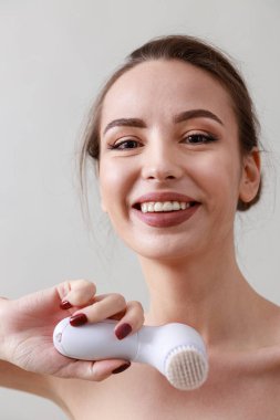 Stüdyo güzelliği portresi. Gri bir arka planda genç, sağlıklı, güzel, taze tenli beyaz bir kadın.