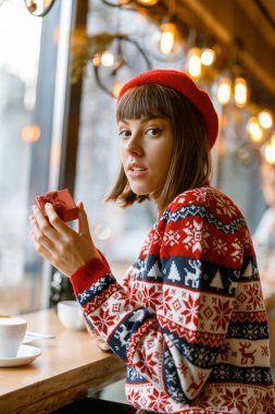 Neşeli, mutlu ve güzel Kafkasyalı bayan rahat bir kafede dinleniyor.