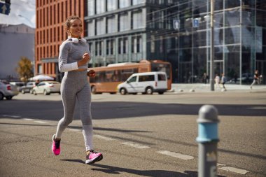 Güzel, sağlıklı, neşeli kadın şehir caddesinde çalışıyor.