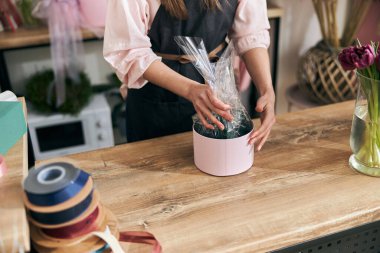 Profesyonel çiçekçi genç bayan çiçekçide buket yapıyor.