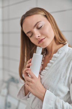 Ev banyosunda taze, doğal cilde sahip genç bir bayan.