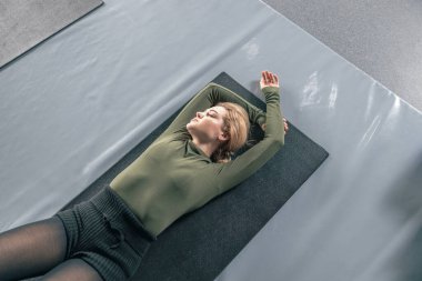 Proffesional güzel beyaz kadın modern stüdyoda esneme egzersizleri yapıyor.