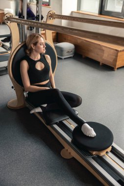 Proffesional güzel beyaz kadın modern stüdyoda esneme egzersizleri yapıyor.