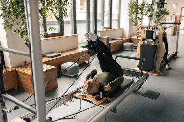 Proffesional güzel beyaz kadın modern stüdyoda esneme egzersizleri yapıyor.