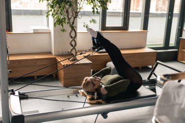 Proffesional güzel beyaz kadın modern stüdyoda esneme egzersizleri yapıyor.