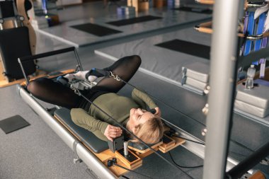 Proffesional güzel beyaz kadın modern stüdyoda esneme egzersizleri yapıyor.