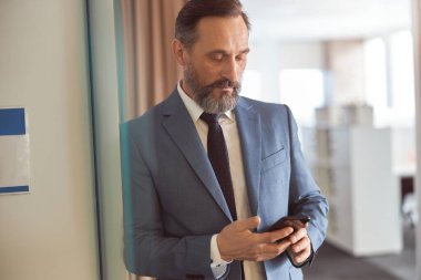 Mutlu yetişkin beyaz adam modern bir ofiste çalışıyor.