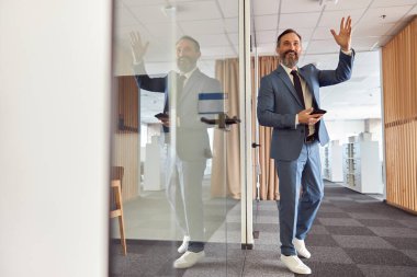 Mutlu yetişkin beyaz adam modern bir ofiste çalışıyor.