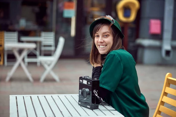 Donna felice in abito verde in città urbana è seduto vicino al caffè — Foto Stock