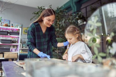 Farklı türde kurutulmuş çiçekleri olan çiçekçi dükkanı. Genç, mutlu, kendine güvenen bir uzman kız çocuğuyla çalışıyor..