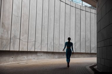 Güzel formda genç bir bayan koşucu dışarıda koşuyor.