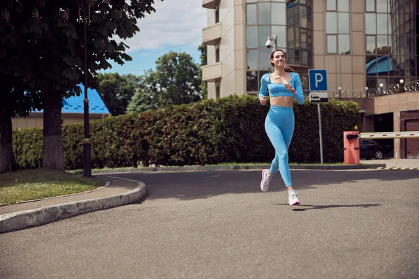Hermosa mujer joven jogger en forma está corriendo al aire libre — Foto de Stock
