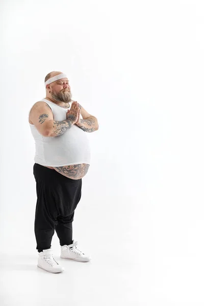 Boldog kövér férfi nagy hasú és tetovált sport viselet pózol fehér háttér — Stock Fotó
