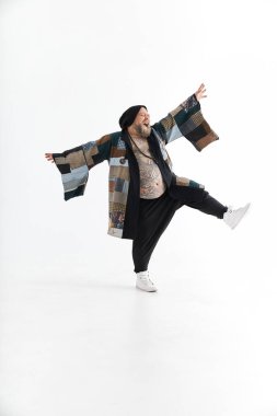 Şişman, sakallı, koca göbekli beyaz adam etnik kimono giyip dans ediyor.