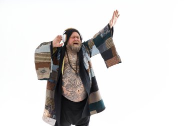 Şişman, sakallı, koca göbekli beyaz adam etnik kimono giyip dans ediyor.