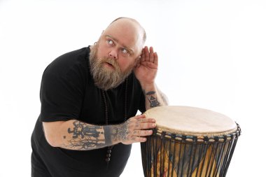 Beyaz sakallı beyaz adam beyaz arka planda poz veriyor.